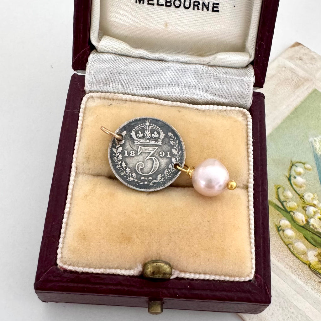 Antique 1891 threepence and pearl rop charm on an old jewellery box