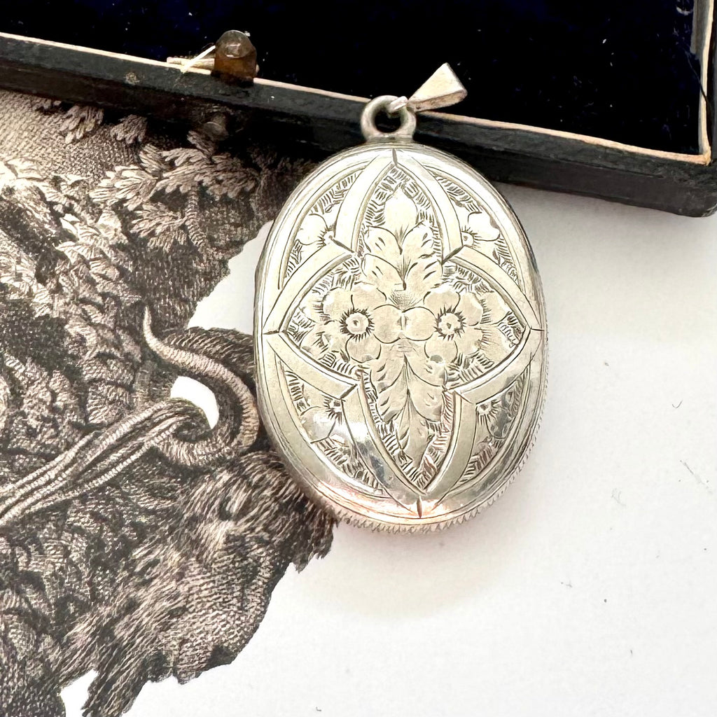 Antique Victorian era silver locket with an engraving of an urn and an old jewellery box