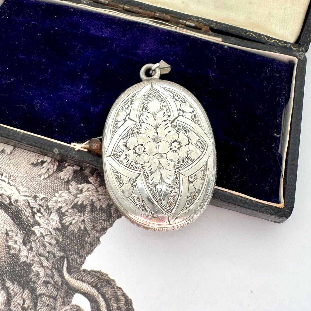 Antique Victorian era silver locket with an engraving of an urn and an old jewellery box