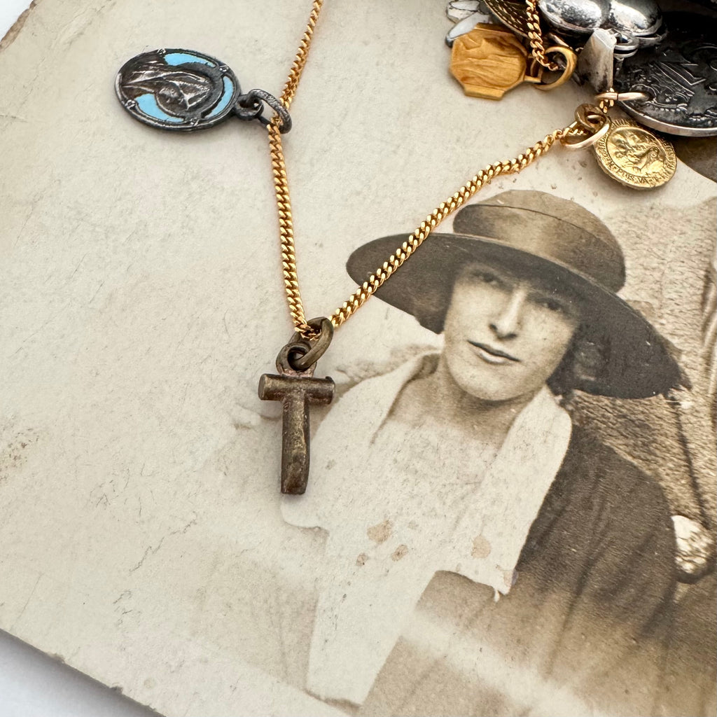 An antique religious charm on an old photo of a woman wearing a hat