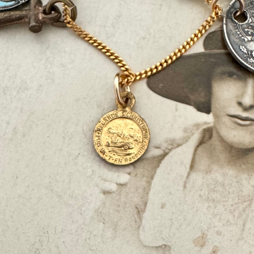 An antique religious charm on an old photo of a woman wearing a hat