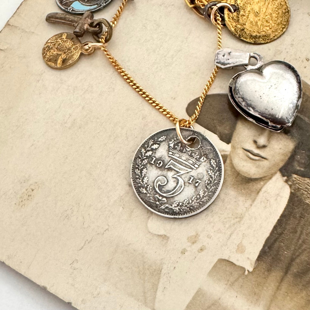 An antique 1917 coin charm on an old photo of a woman wearing a hat