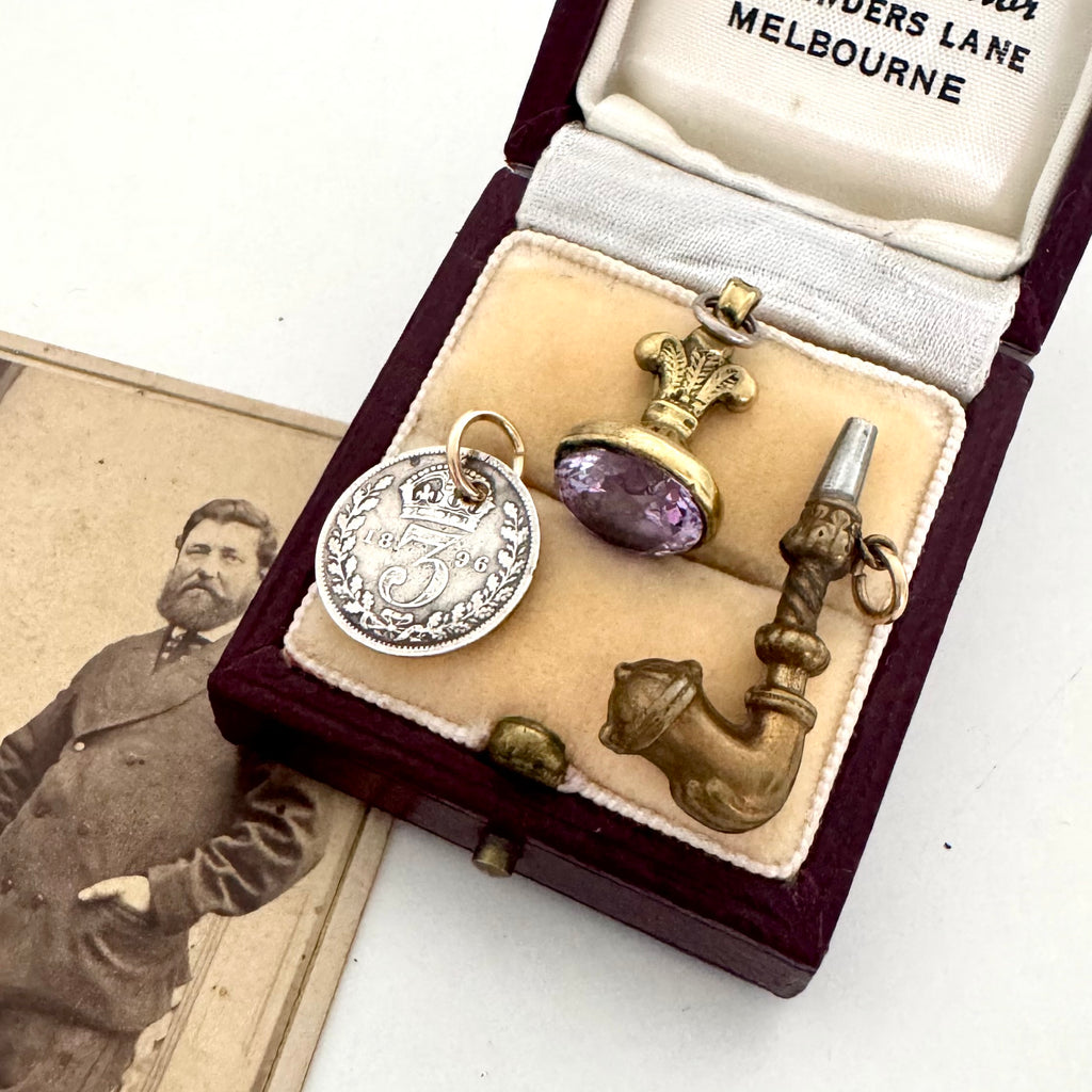 Vintage jewelry set in a display case with an old photograph of a man.