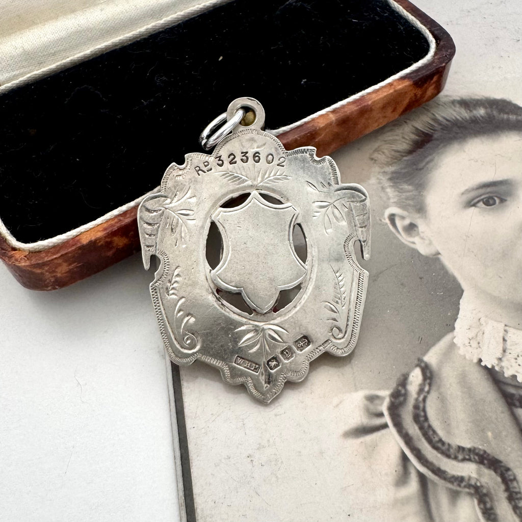 Large antique William Hair Haseler silver watch fob on an old photograph of a woman and jewellery box