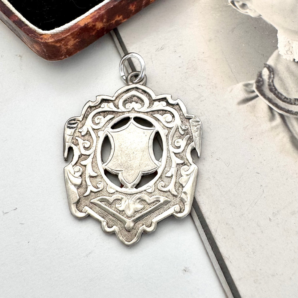 Large antique William Hair Haseler silver watch fob on an old photograph of a woman and jewellery box