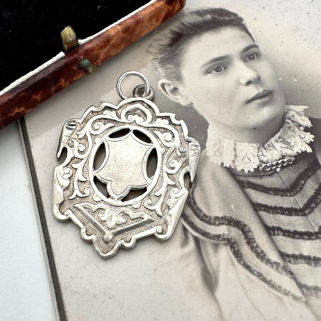 Large antique William Hair Haseler silver watch fob on an old photograph of a woman and jewellery box