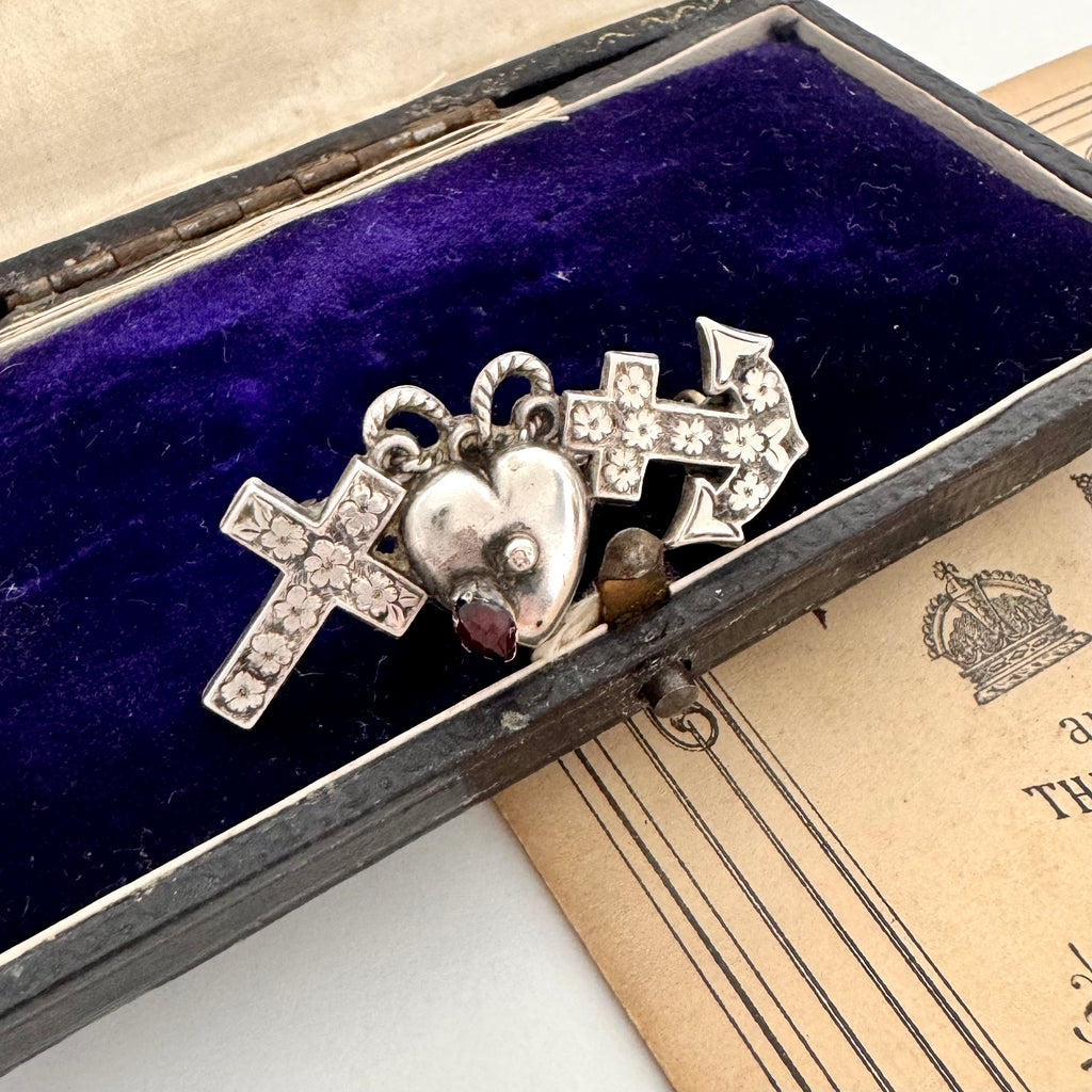 Antique 1901 faith, hope and charity brooch on a vintage jewellery box.