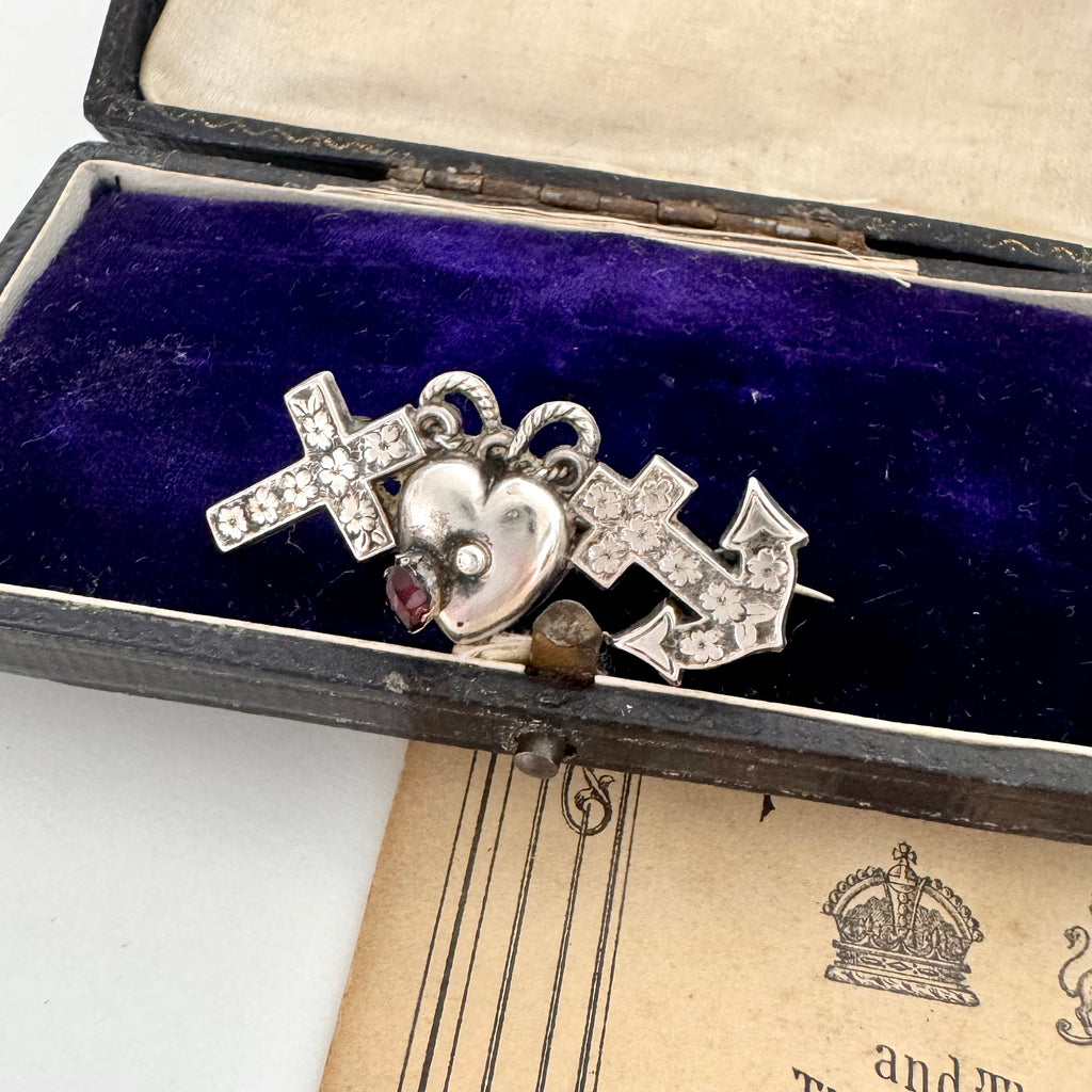 Antique 1901 faith, hope and charity brooch on a vintage jewellery box.