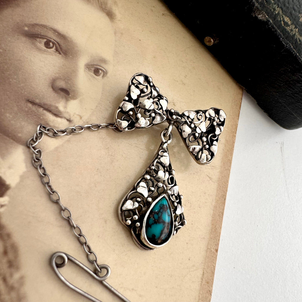 Vonk Jewellery silver arts and crafts bow brooch with turquoise drop on an antique photo of a woman