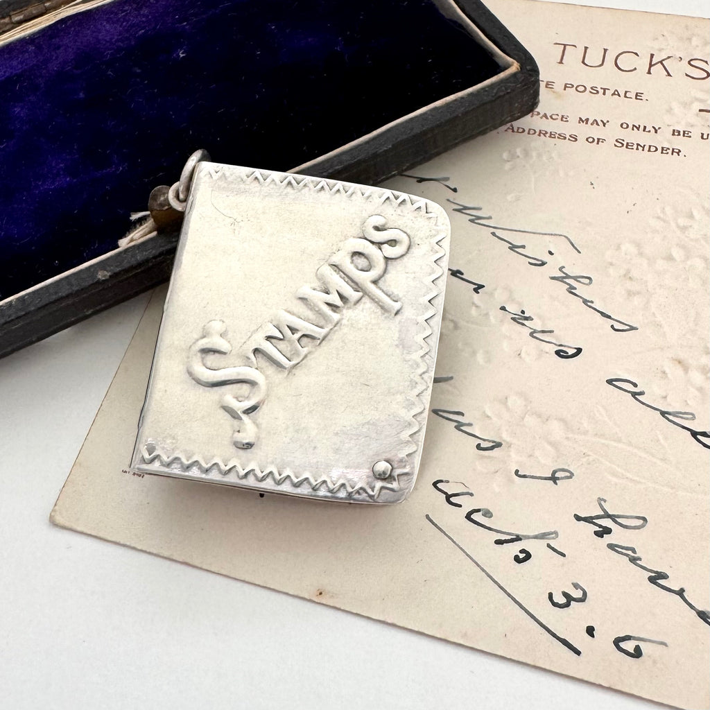 Silver stamp case with 'Stamps' engraving on an old letter
