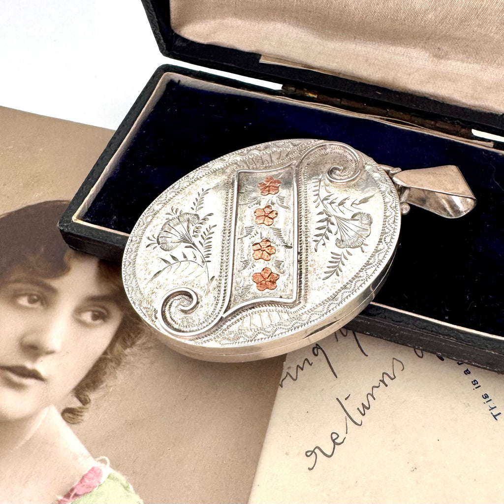 Antique 1885 sterling silver and rose gold locket with an old postcard of a woman and on an old jewellery box