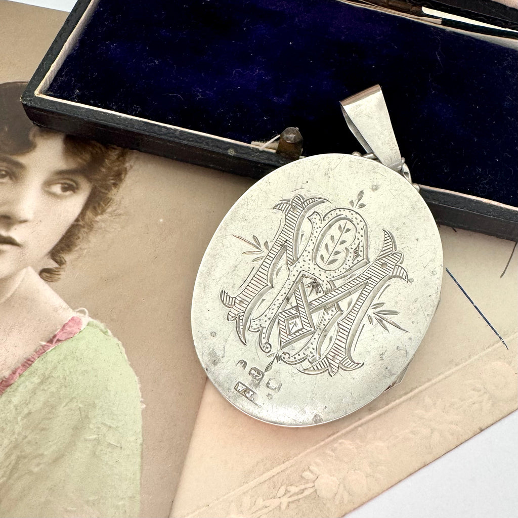 Antique 1885 sterling silver and rose gold locket with an old postcard of a woman.