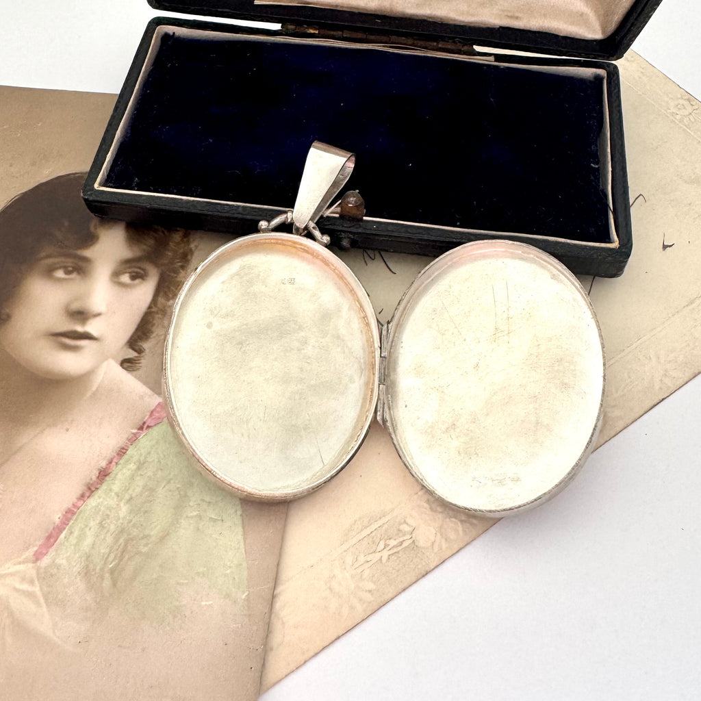 Open antique 1885 sterling silver and rose gold locket with an old postcard of a woman.
