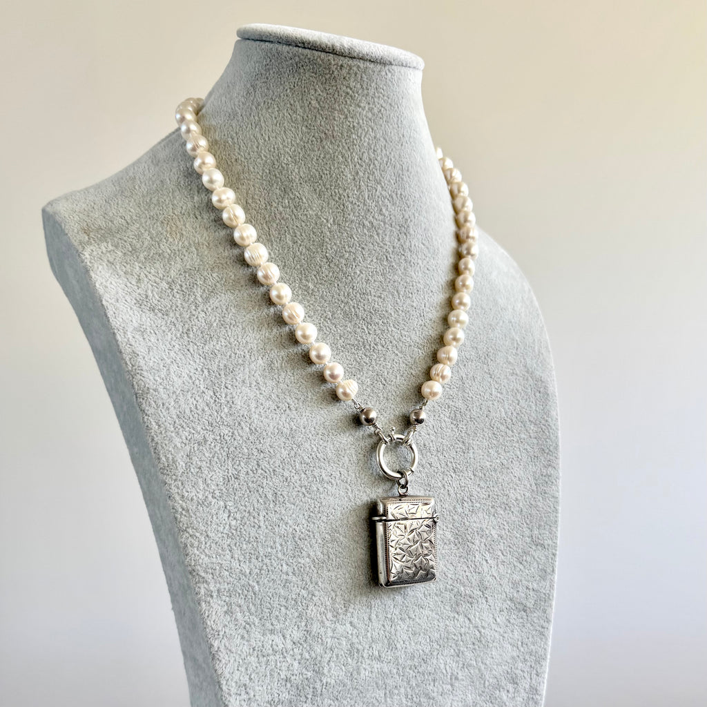Vonk Jewellery antique sterling silver vesta case on a pearl necklace. The necklace is on a pale grey velvet jewellery display neck.