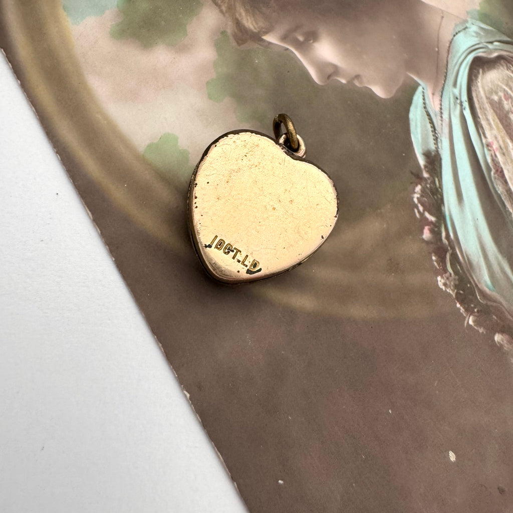 Vintage gold heart shaped heart locket on a vintage photograph background