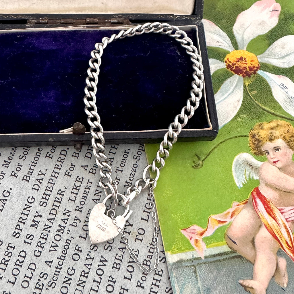 Silver bracelet with heart charms on a vintage-style card with text and an angel illustration.