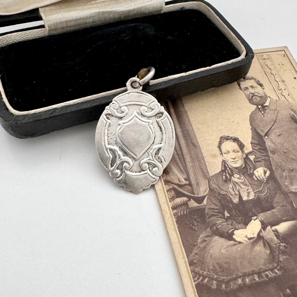 Vintage 1957 silver watch fob on an old jewellery box and photo