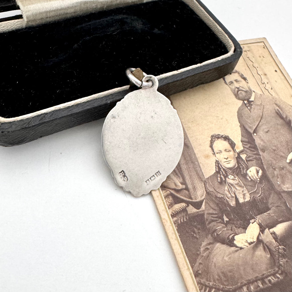 Vintage 1957 silver watch fob on an old jewellery box and photo