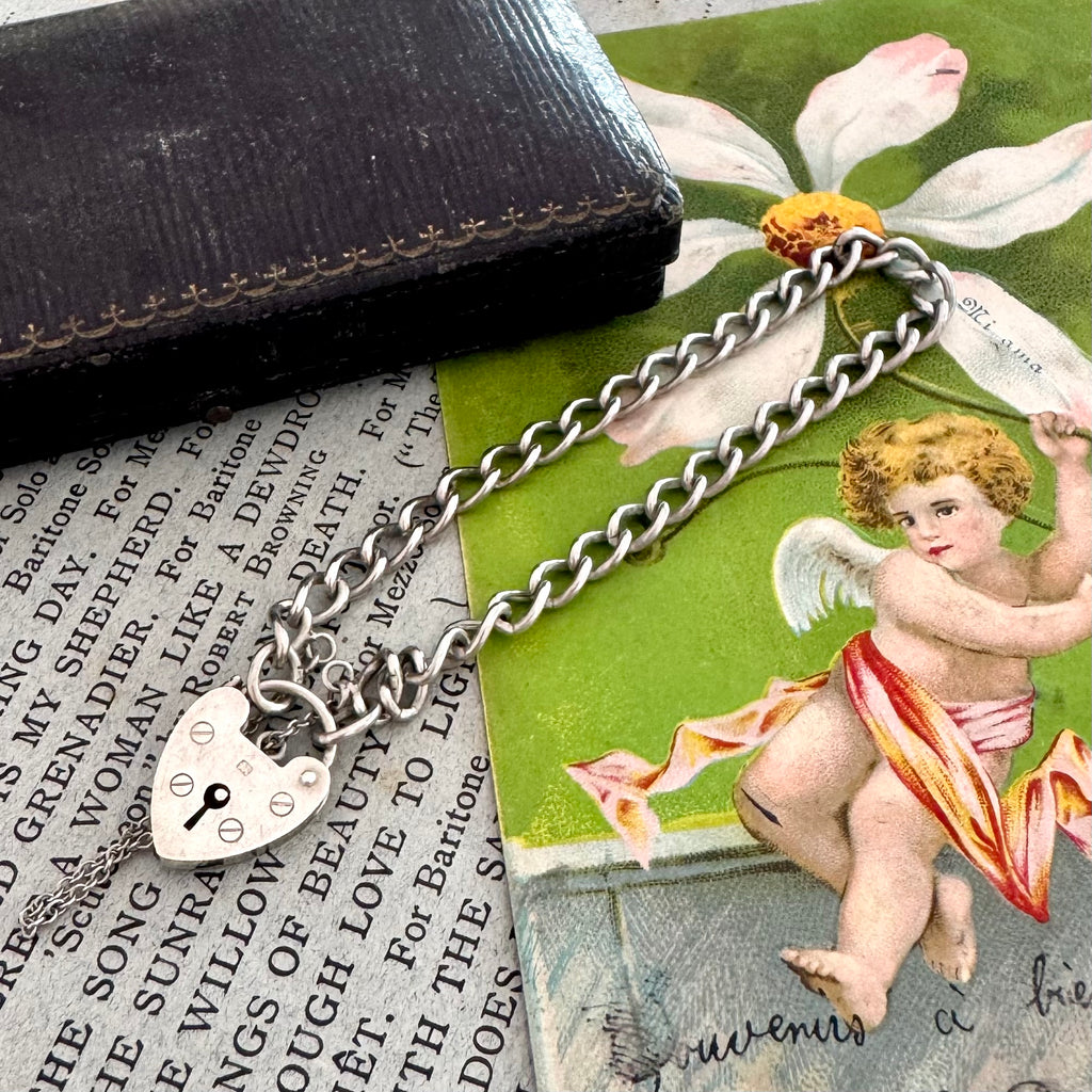 Vintage silver bracelet with an angelic figure and vintage text in the background