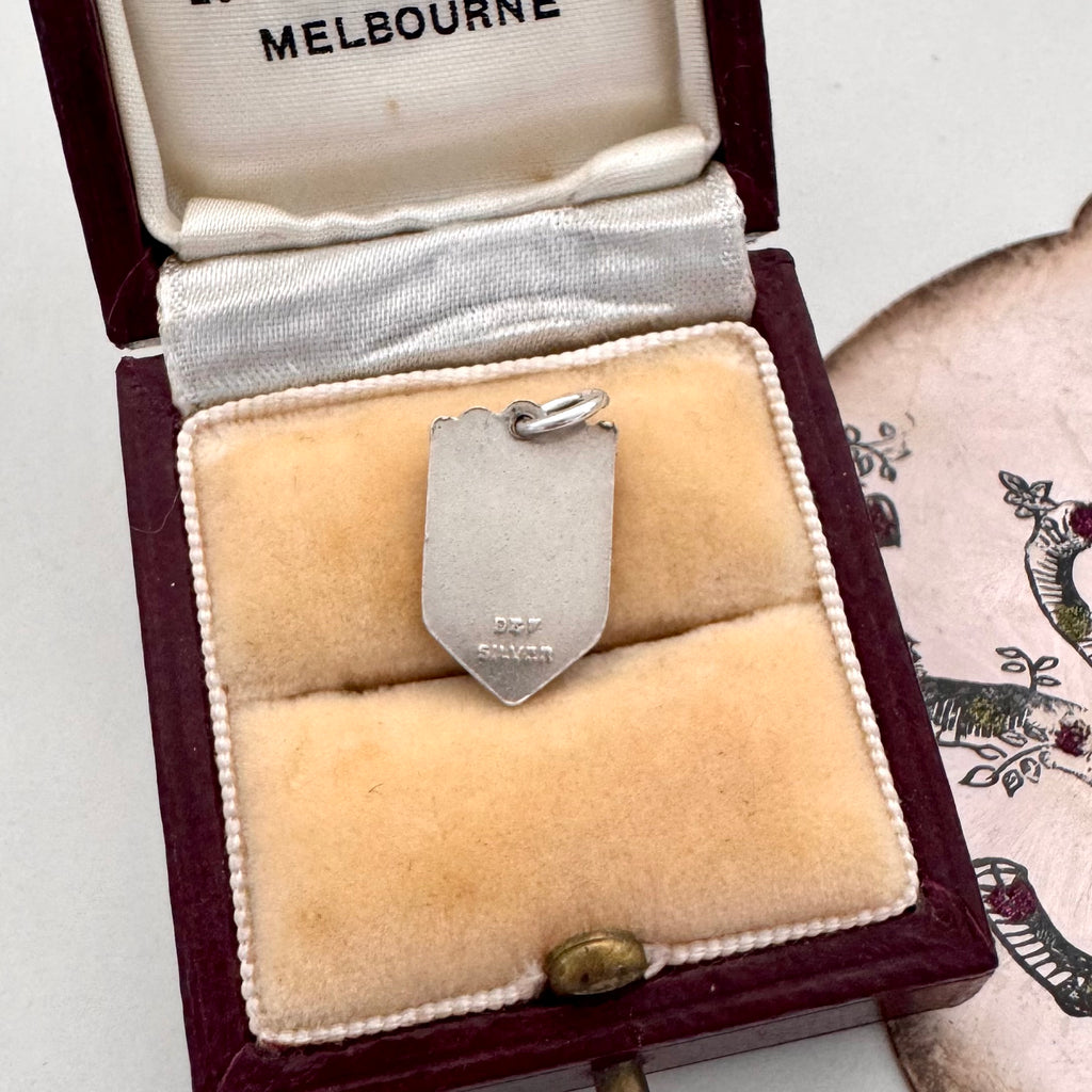 Vintage Norwich silver travel charm on a jewellery box