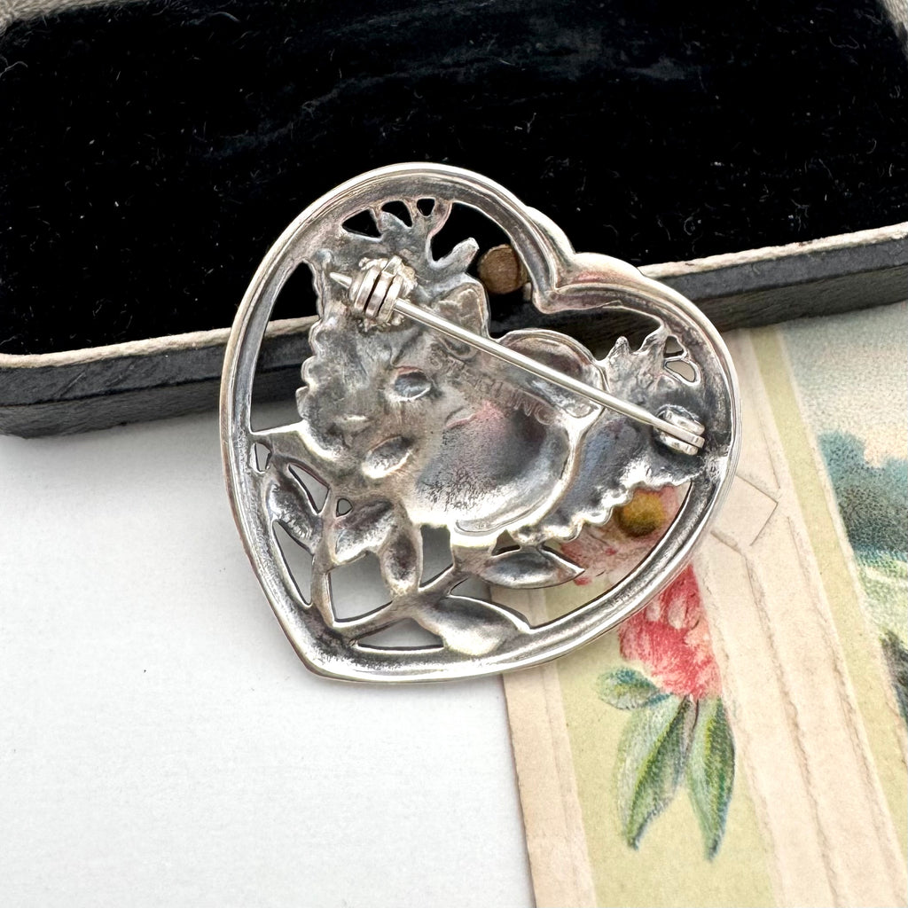 Silver brooch with a design on a textured surface