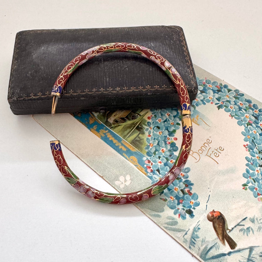 Vintage brown cloisonne bangle on an old jewellery box and vintage Christmas postcard.