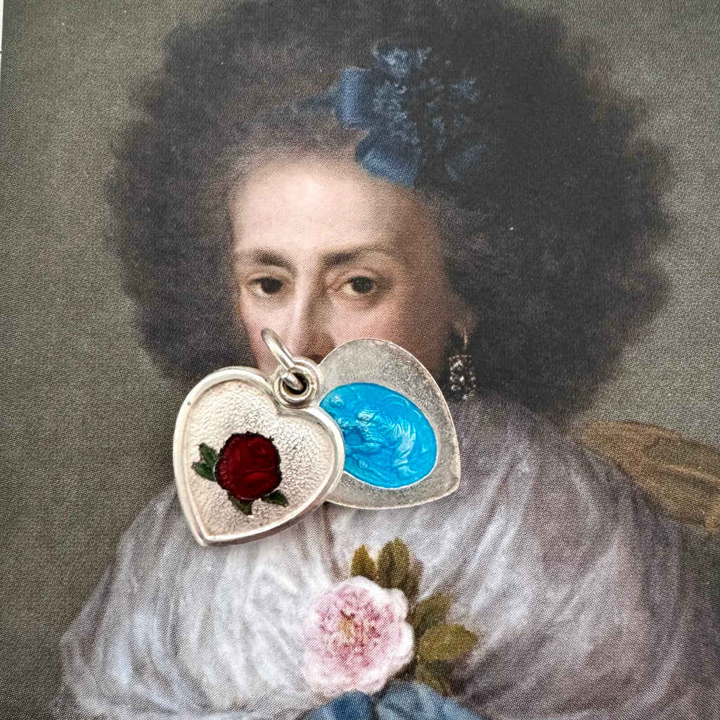 Vintage enamel guilloche heart and St Christopher charm on an old masters portrait of a woman