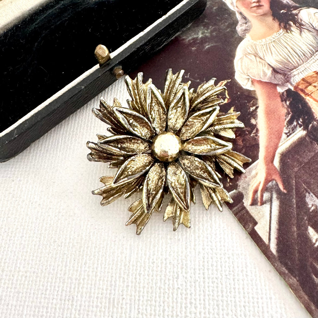 Vintage signed Hollywood gold tone flower brooch on an old jewellery box and with a vintage postcard