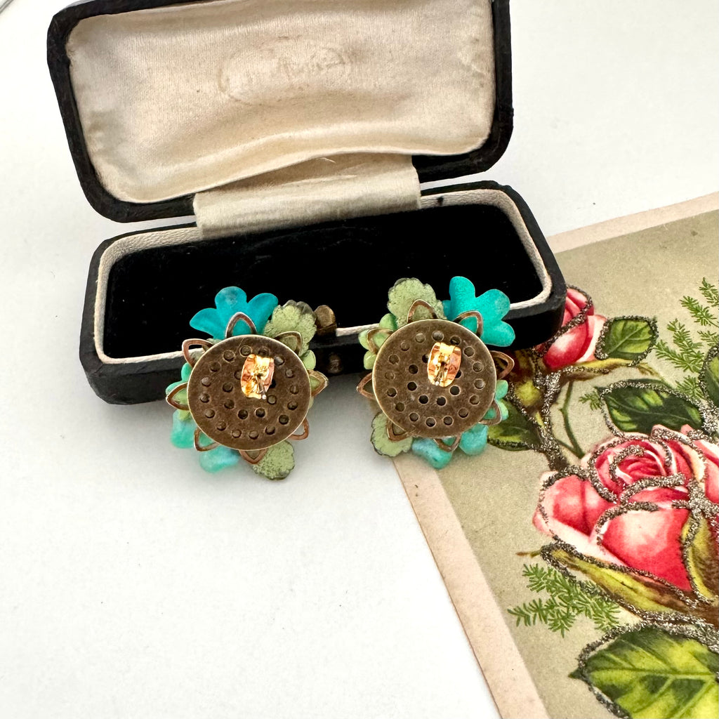 Back of floral earrings in a black jewelry box on a floral-themed card.