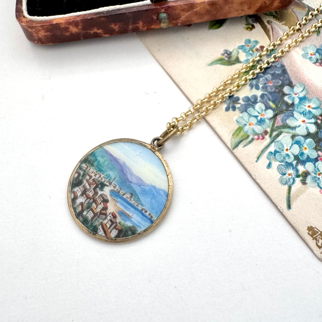 Vintage hand painted pendant featuring a scene of Rapallo on the Italian riviera. It is with a vintage postcard and old jewellery box