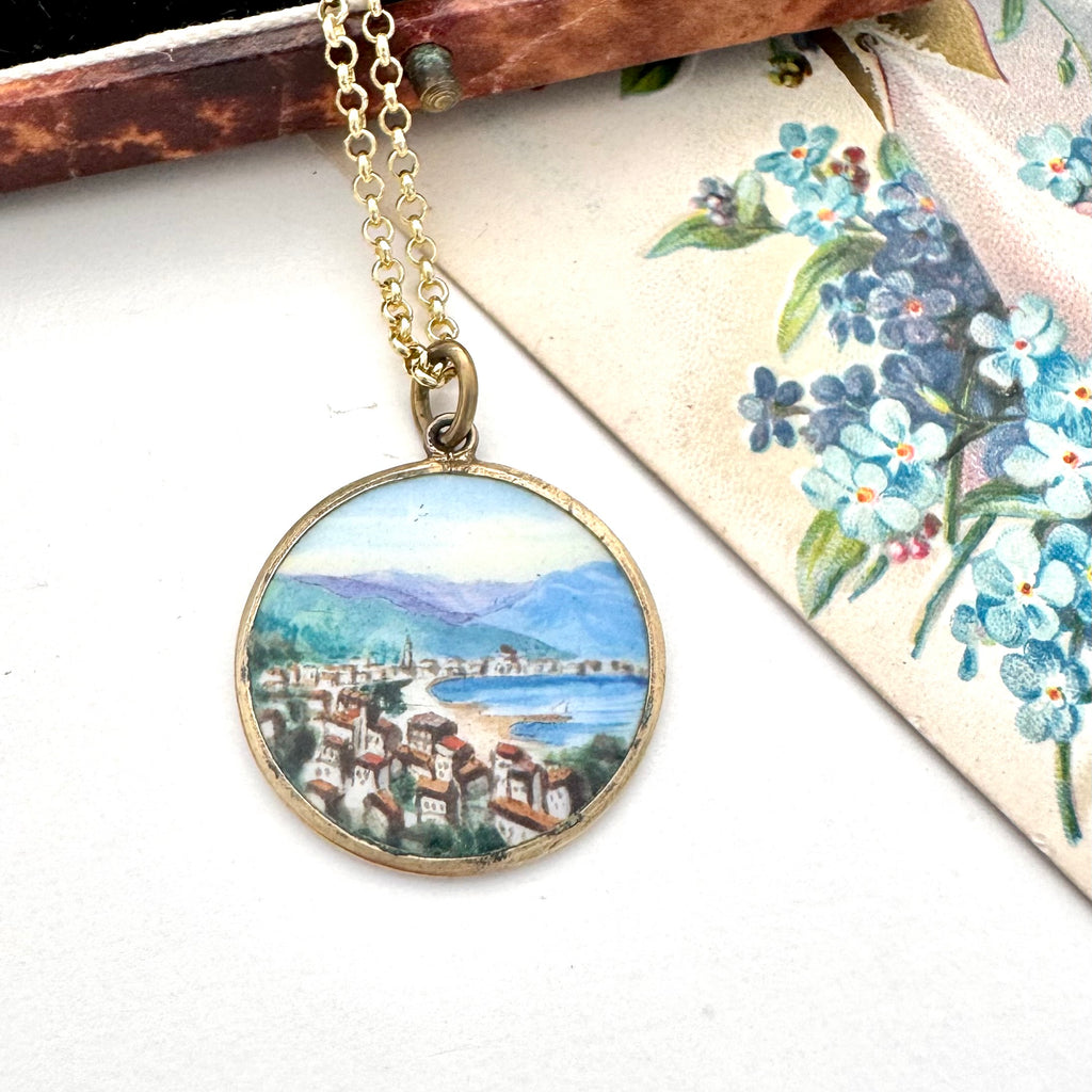 Vintage hand painted pendant featuring a scene of Rapallo on the Italian riviera. It is with a vintage postcard and old jewellery box