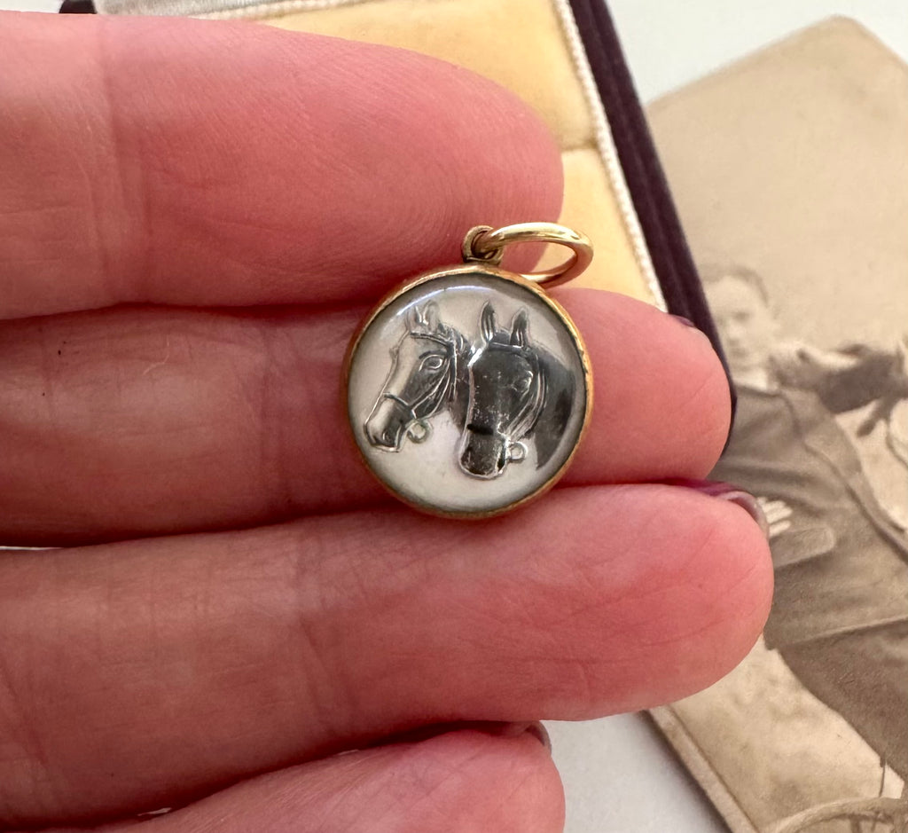 Vintage reverse carved lucite horse charm in a woman's fingers