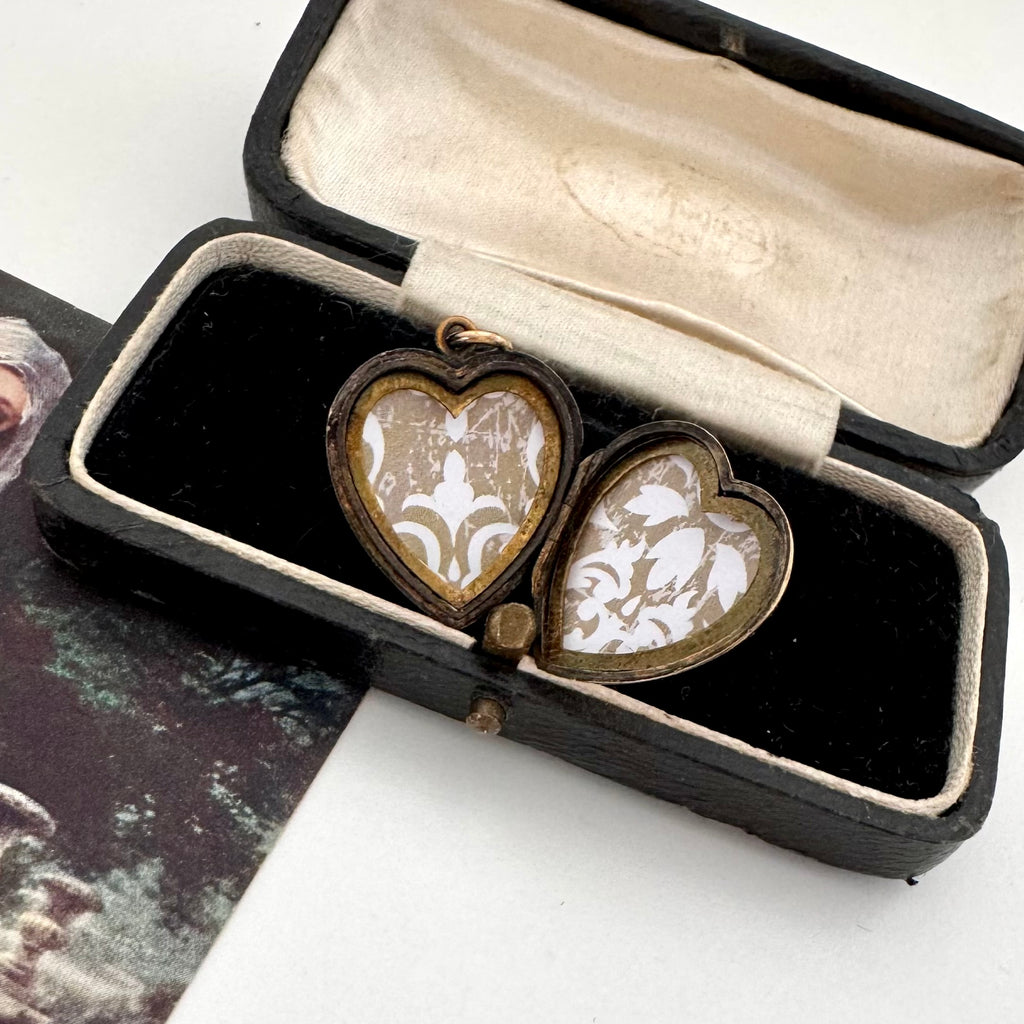 Open vintage heart locket in an old jewellery box