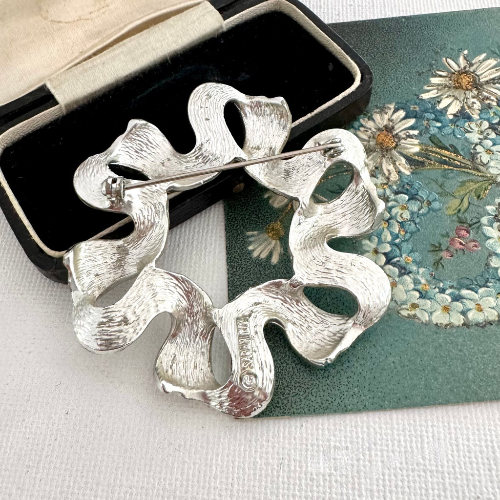 Vintage 1971 silver tone Sarah Coventry ribbonette brooch on an old postcard and with a box