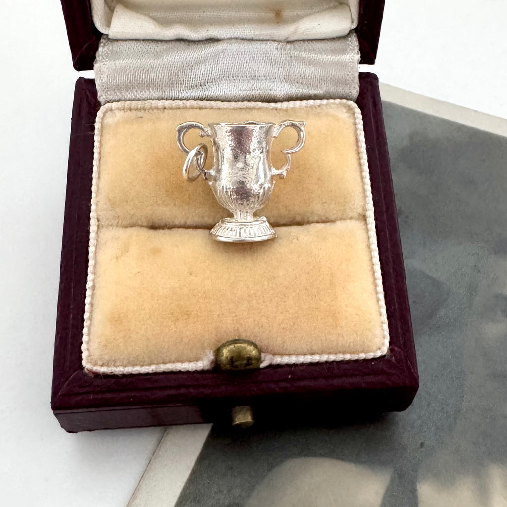 Silver FA Cup trophy-shaped pendant in a jewelry box on a white surface
