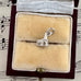 Silver charm in a decorative jewelry box with music sheet background