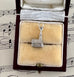 Silver church charm in a jewelry box with sheet music in the background