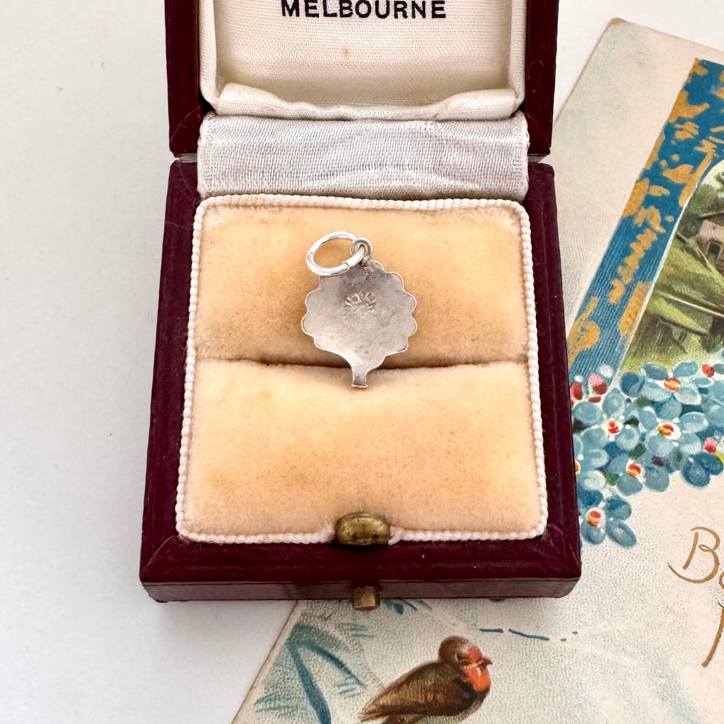 Vintage silver and enamel peacock charm in a jewelry box with 'Melbourne' branding
