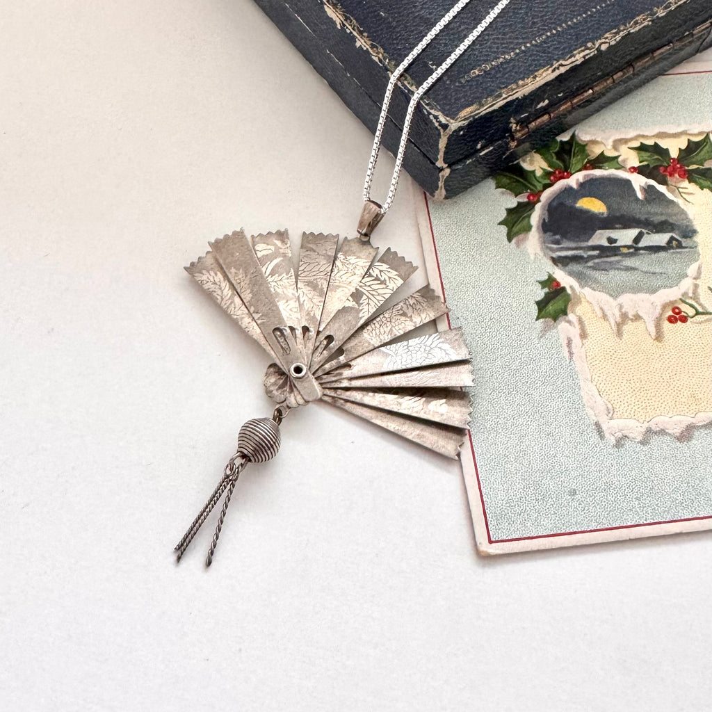 Vintage silver fan necklace on a vintage jewellery box and a vintage Christmas card.