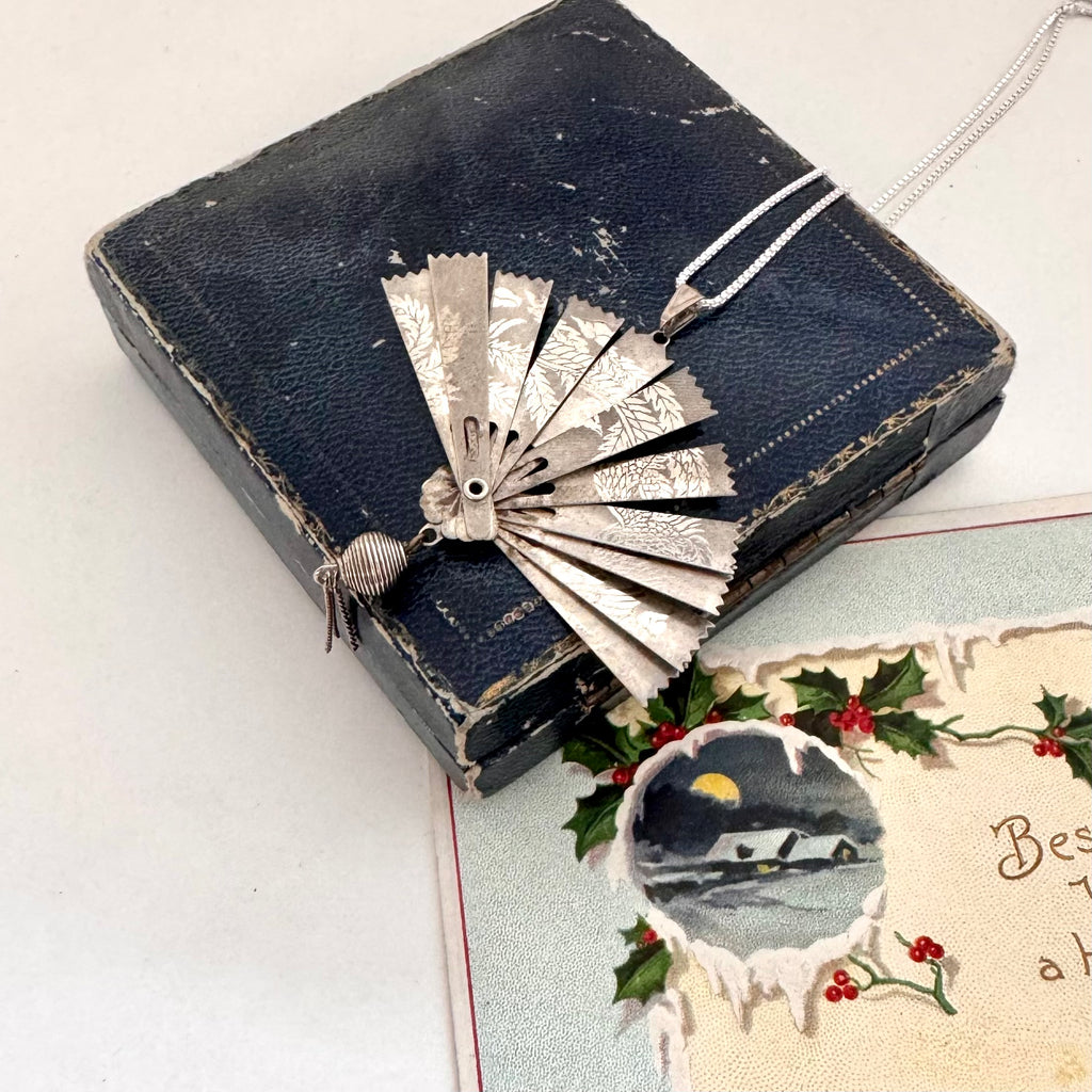 Vintage silver fan necklace on a vintage jewellery box and a vintage Christmas card.