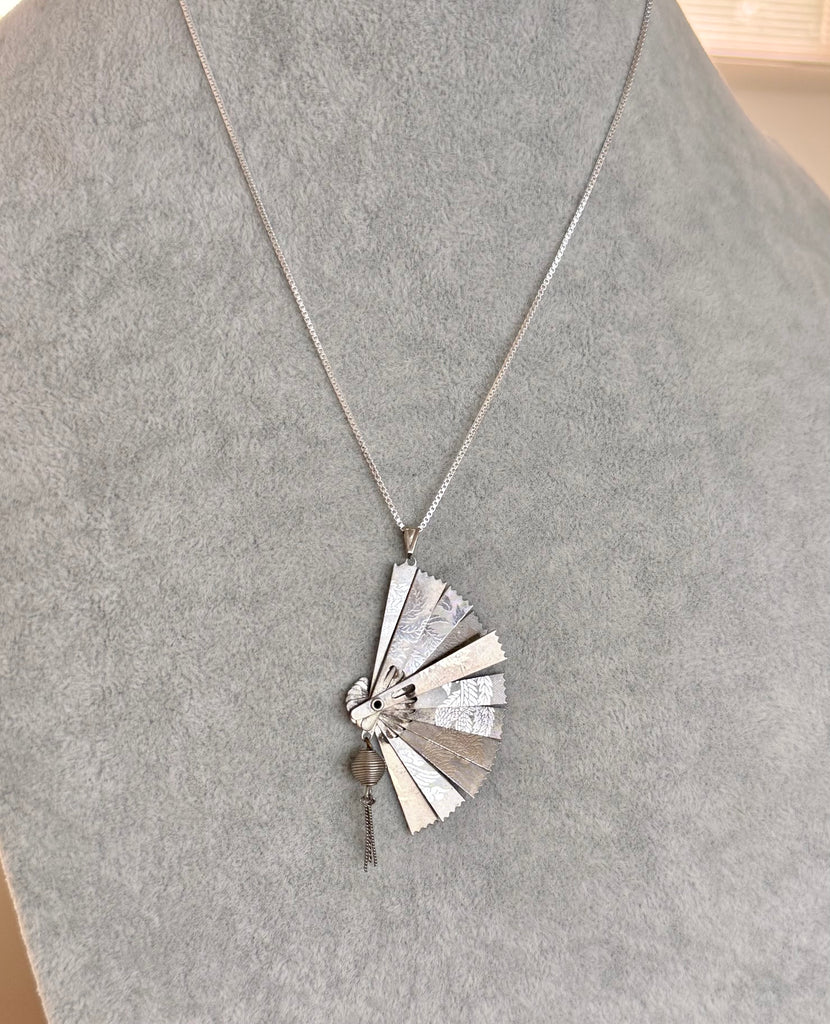 Vintage silver fan necklace on a grey mannequin