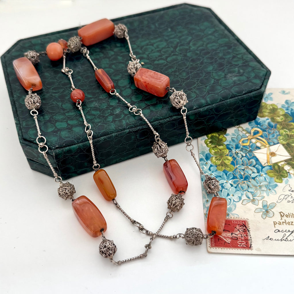 Vintage Middle eastern silver and carnelian chain necklace on a textured green box