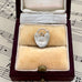 Silver heart-shaped pendant in a jewelry box on sheet music
