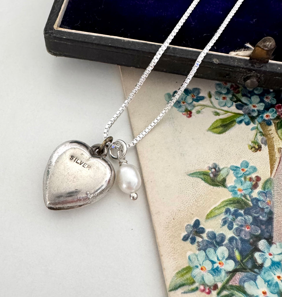 Vintage silver heart and pearl charms on a silver chain. The necklace is with a vintage postcard and vintage jewellery box