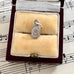 Silver vintage scarab beetle charm in a jewelry box on sheet music