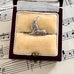 Silver vintage  sphinx charm in a jewelry box on sheet music