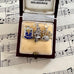 Three vintage silver Scottish themed charms in a jewelry box on sheet music