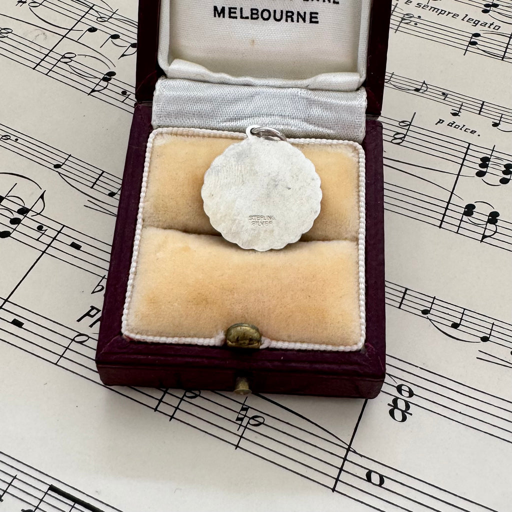 Vintage silver St Christopher in a jewelry box on sheet music