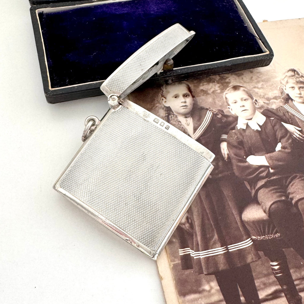 Vintage 1935 hallmarked vesta case made by G&SC Ltd of Regent St, London with a black box and vintage photo of children on a white background