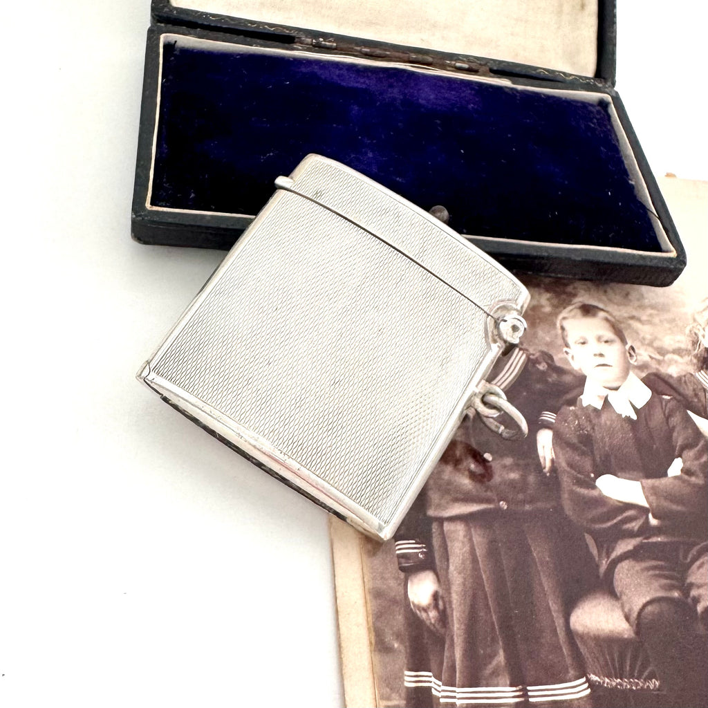 Vintage 1935 hallmarked vesta case made by G&SC Ltd of Regent St, London with a black box and vintage photo of children on a white background